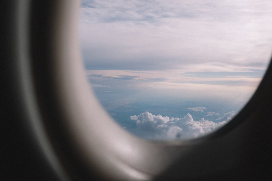 Vue de nuages à travers un hublot par Peter Bucks sur Unsplash.com